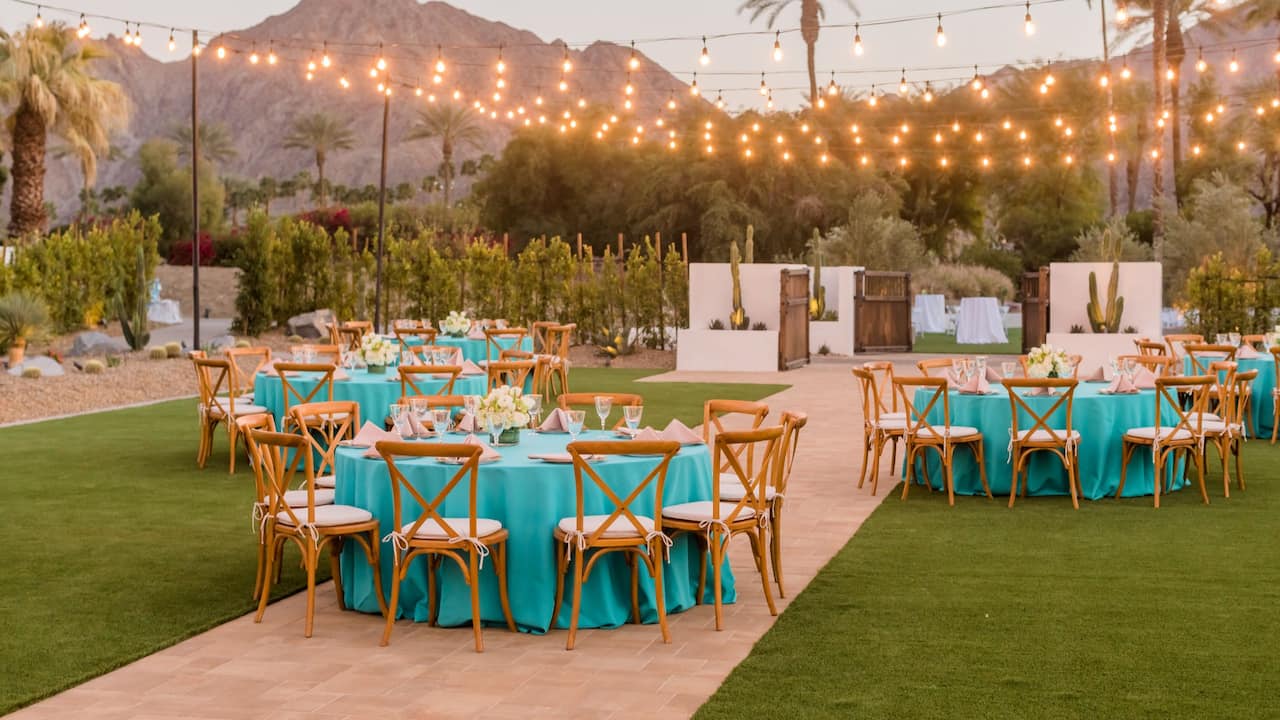 An outdoor wedding reception with green draped tables in Palm Springs