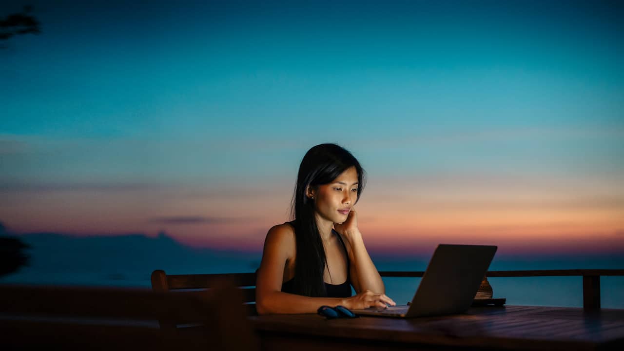 Women working at computer with a sunset in the background