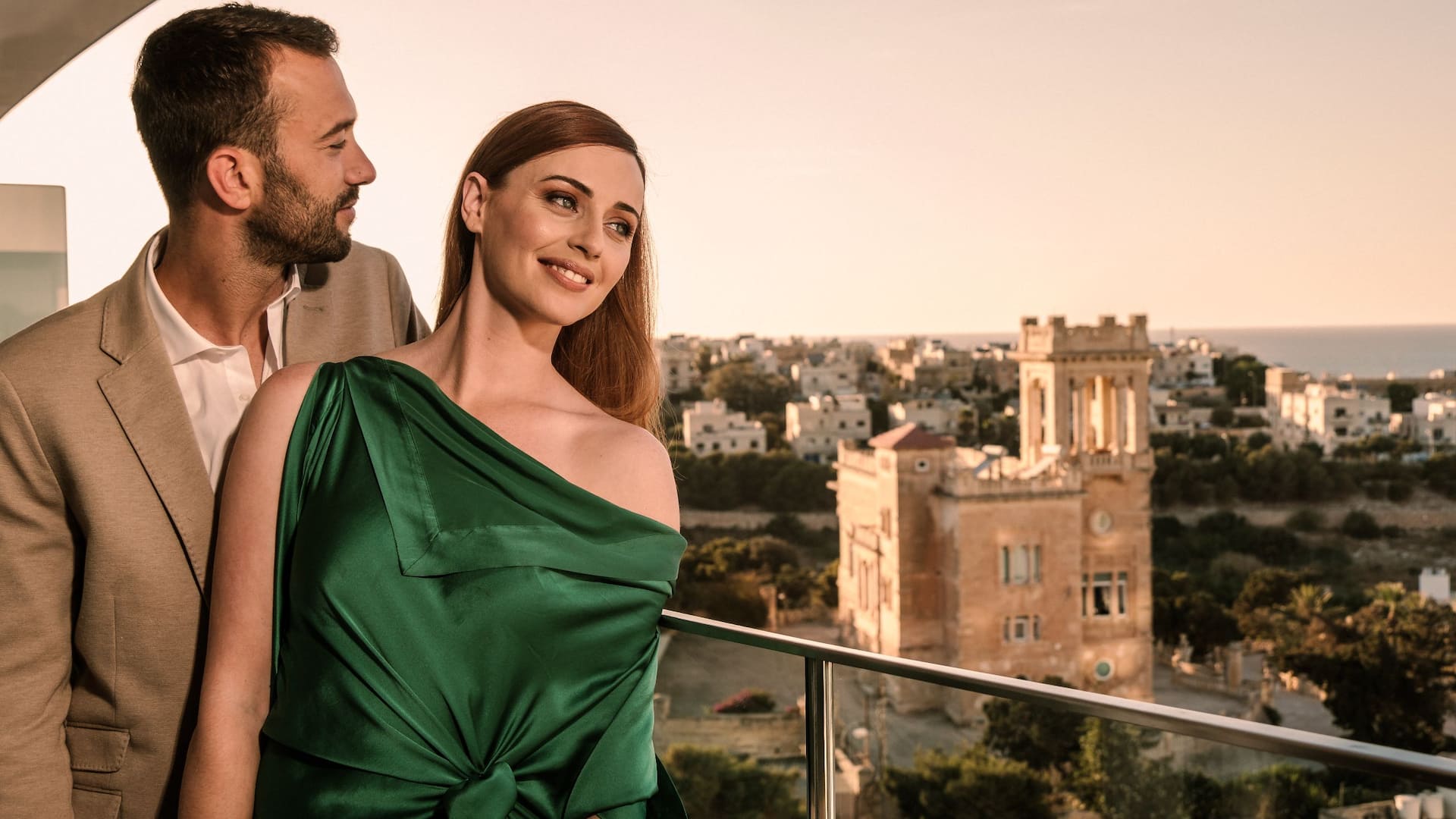 1 of 5 Couple posing on the balcony of a king bed high floor room at the Hyatt Regency Malta
