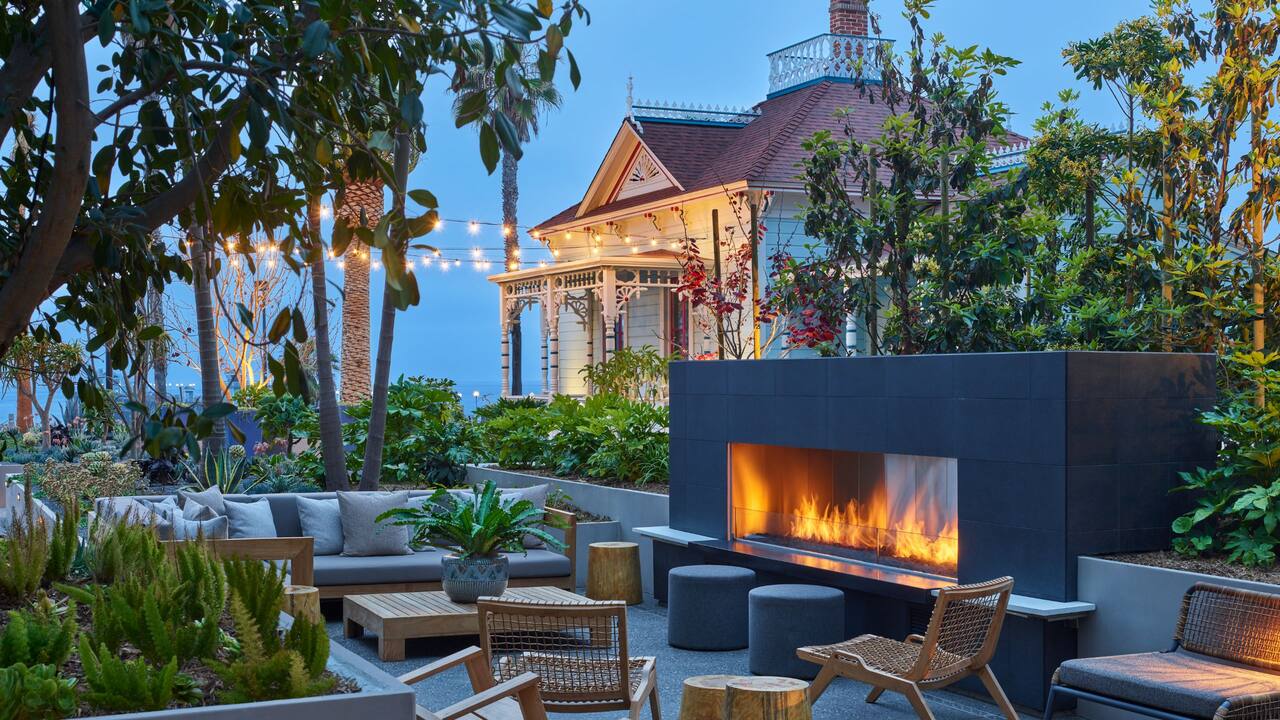 Patio lounge and fireplace at dusk with Pacific Garden venue in background