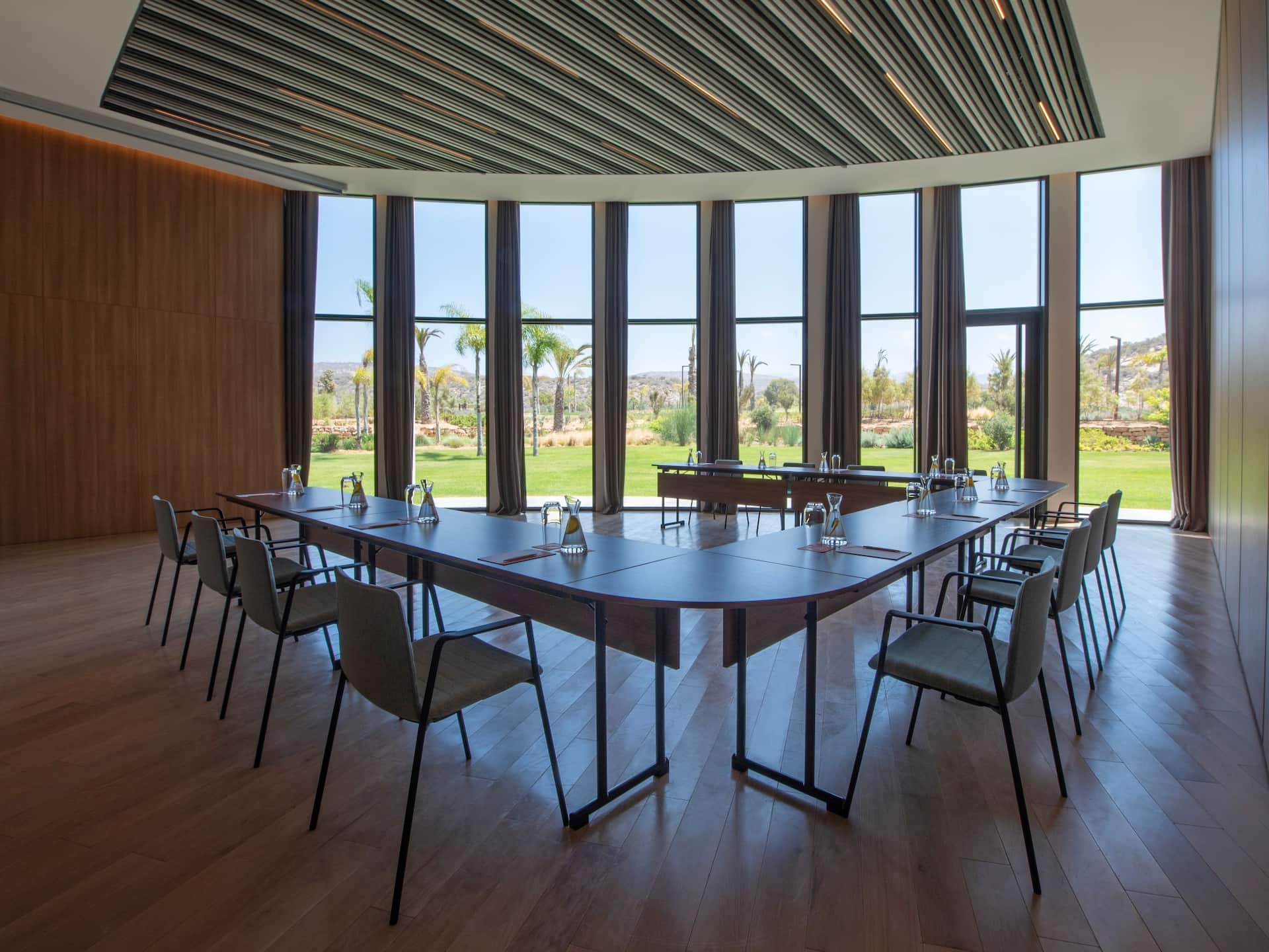 Conference room setup overlooking a garden, providing a bright and serene  atmosphere for meetings.