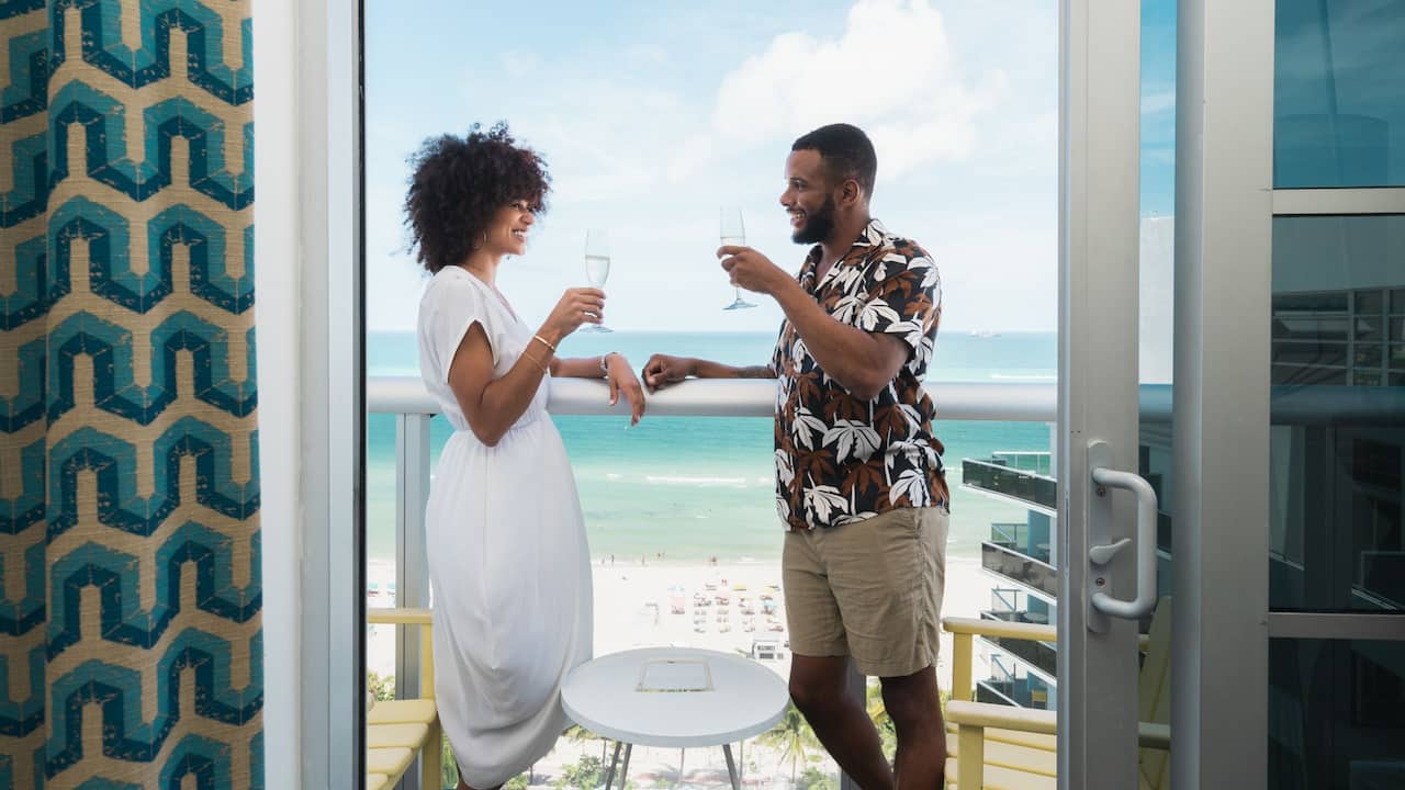 Oceanfront Balcony Suite with couple toasting each other