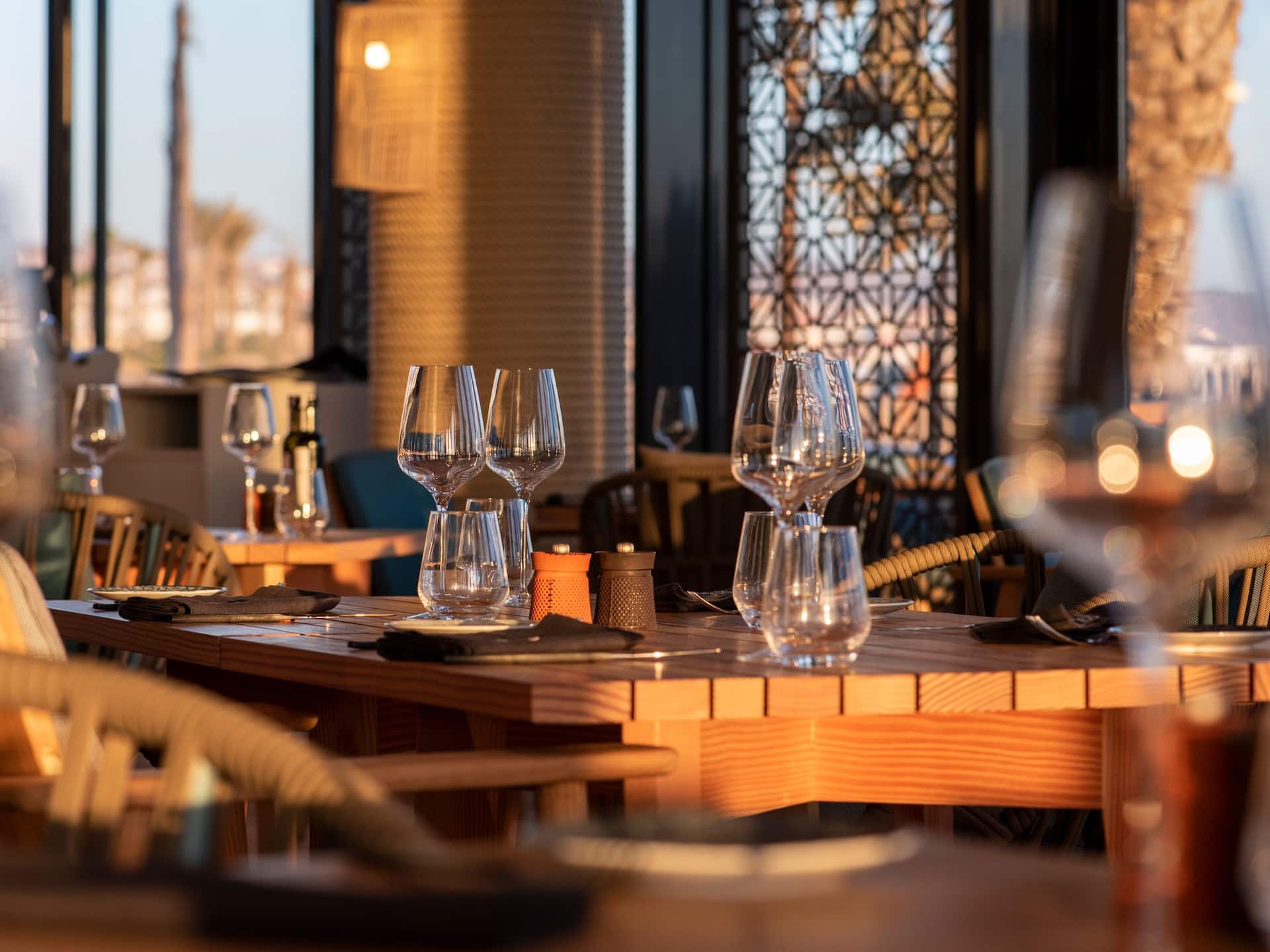 Wooden table setup indoors, bathed in sunlight, creating a warm and inviting  atmosphere