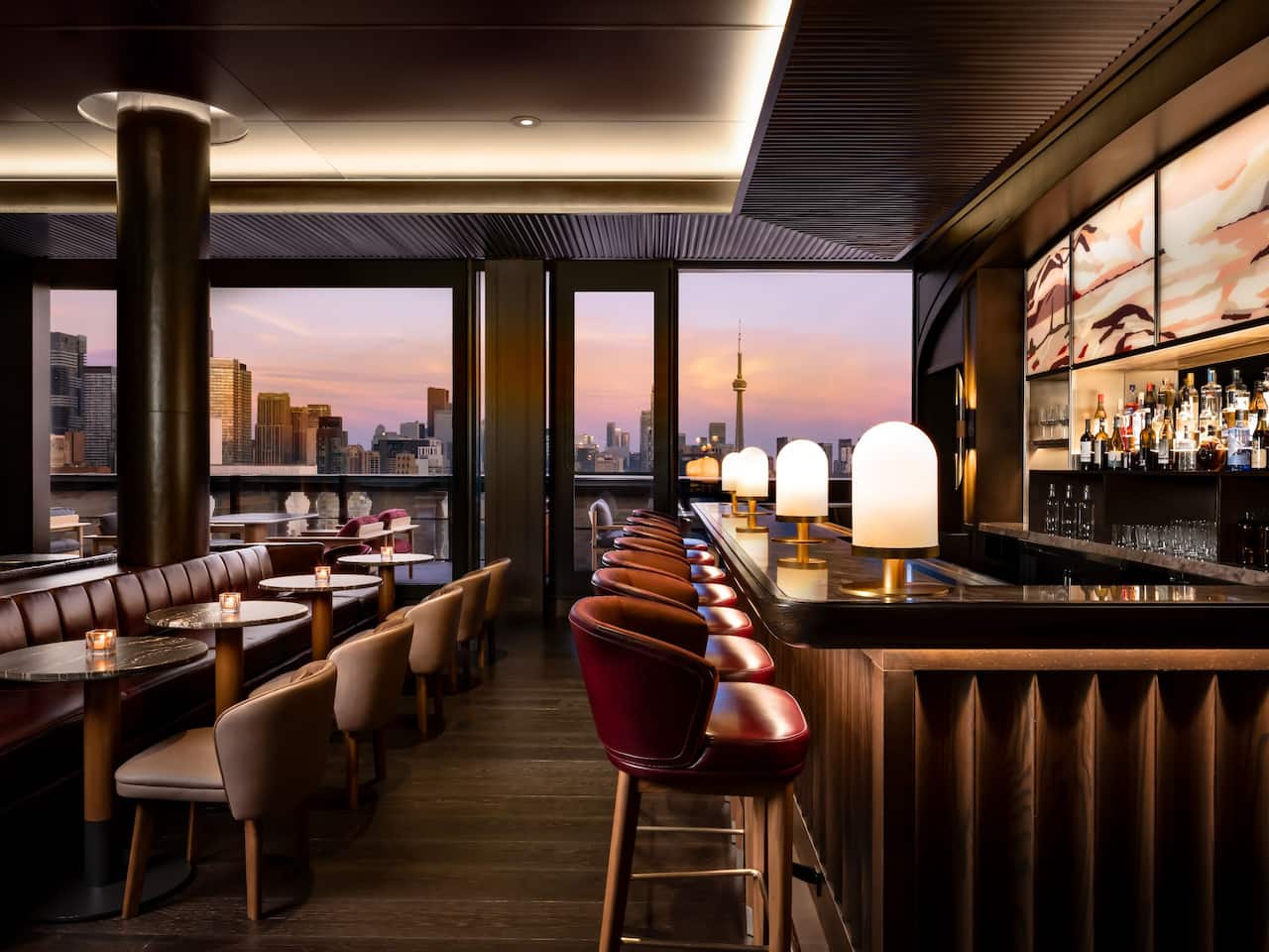 A elegant spacious rooftop bar with a view of the Torononto city skyline