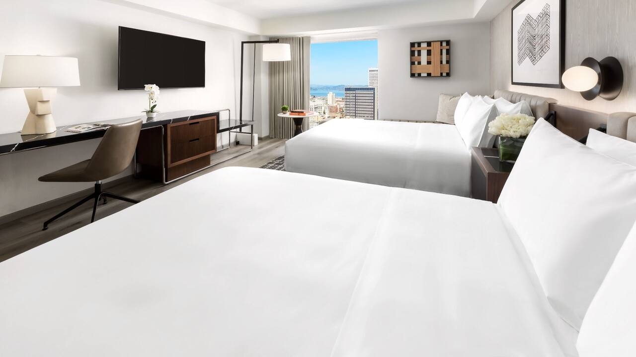 Two Queen Beds with City View featuring desk, small table, and TV