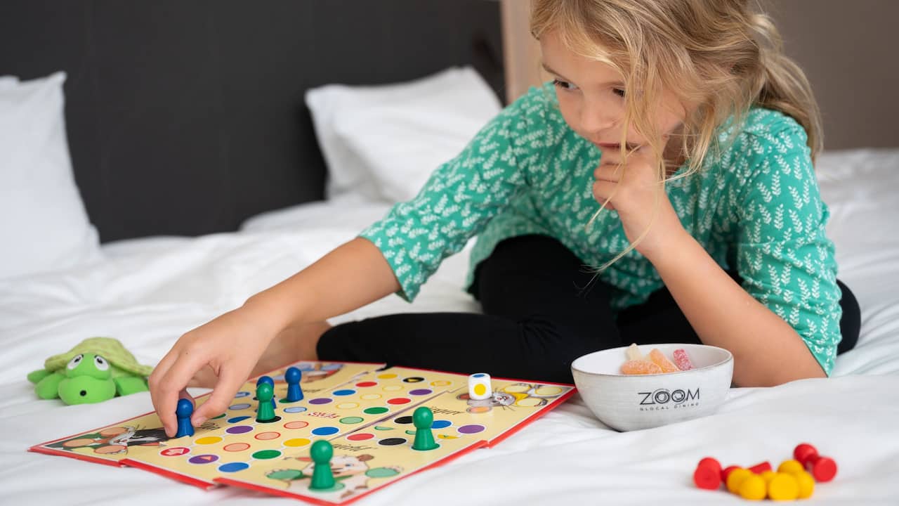 Child playing board game on bed at Hyatt Place Frankfurt Airport