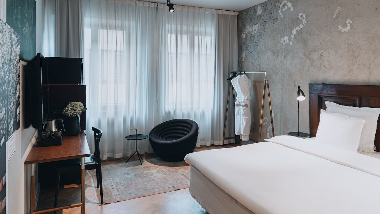Story Hotel Riddargatan photo of whole king bed room, including bed, work desk, TV, armchair and bathrobes.
