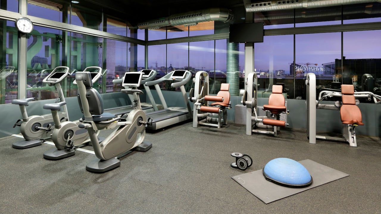 Sala de fitness totalmente equipada con vistas a la ciudad en nuestro hotel Hyatt Regency Hesperia Madrid.