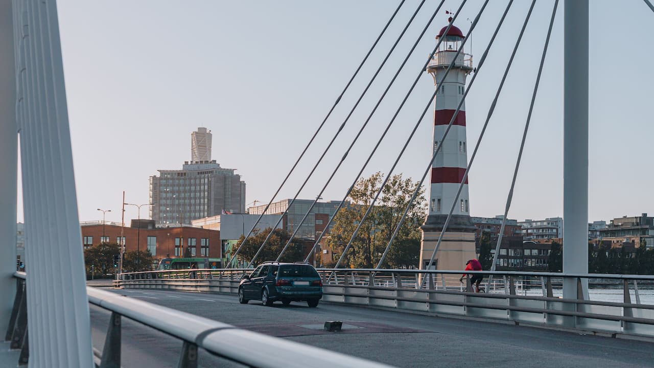 Car crossing the bridge outside Story Hotel and Malmo Lighthouse in background 