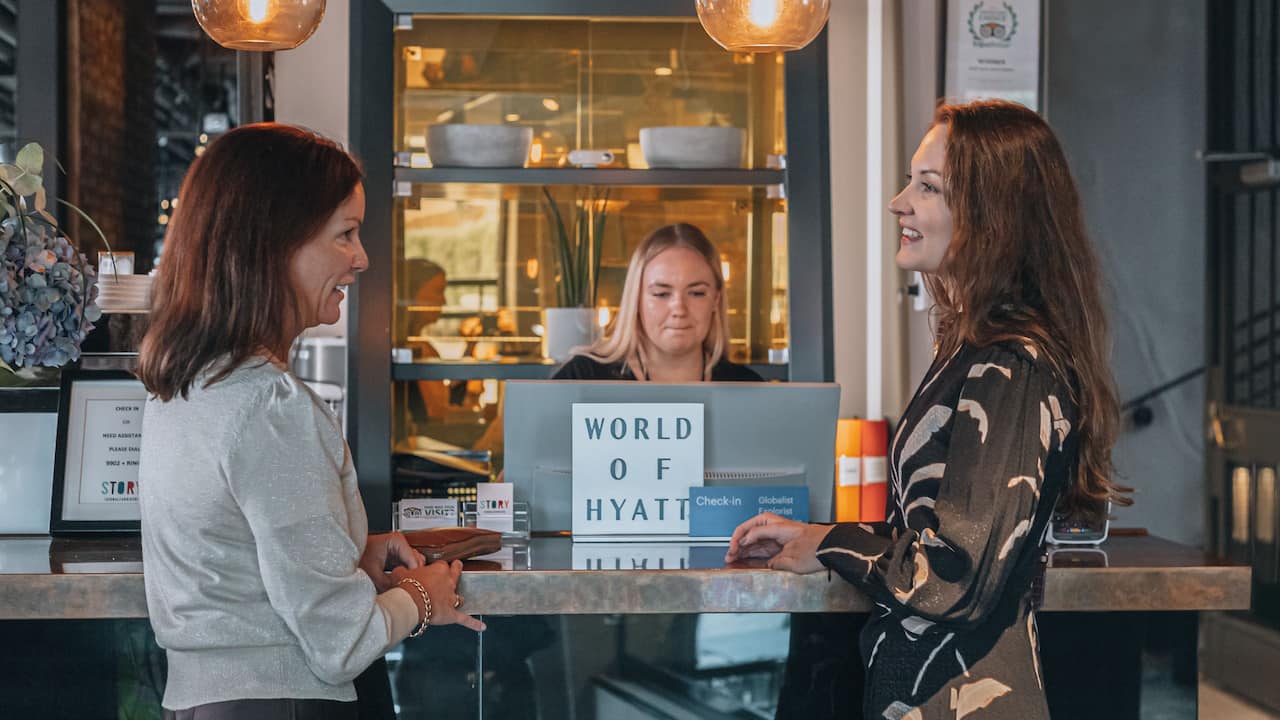 Happy Guests Checking In at the Front Desk at Story Hotel Signalfabriken in Sundbyberg