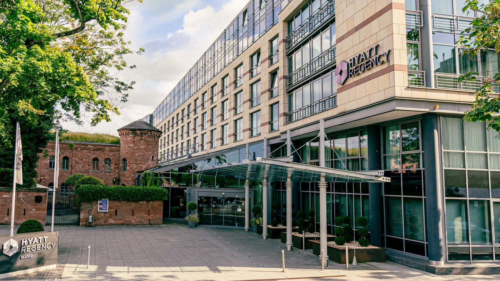 Hyatt Regency Mainz hotel building with adjacent historic Fort Malakoff during sunny day in spring