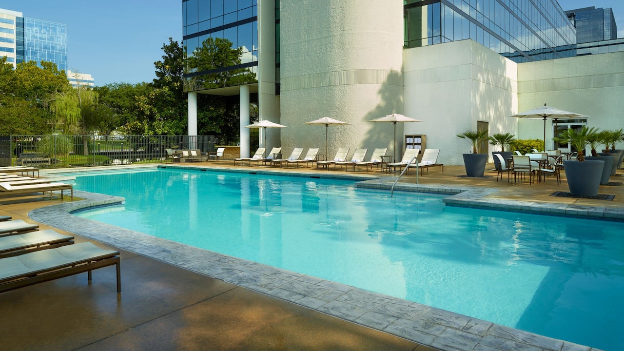 Outdoor pool with loungers and sun umbrellas