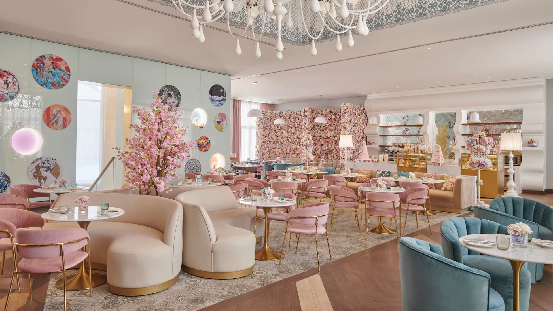 1 of 1 Rosalie Cafe, a charming French patisserie at Grand Hyatt Al Khobar, featuring an elegant and whimsical interior with pastel pink and blue seating, gold accented tables, and floral decor, A beautiful cherry blossom tree and a flower wall