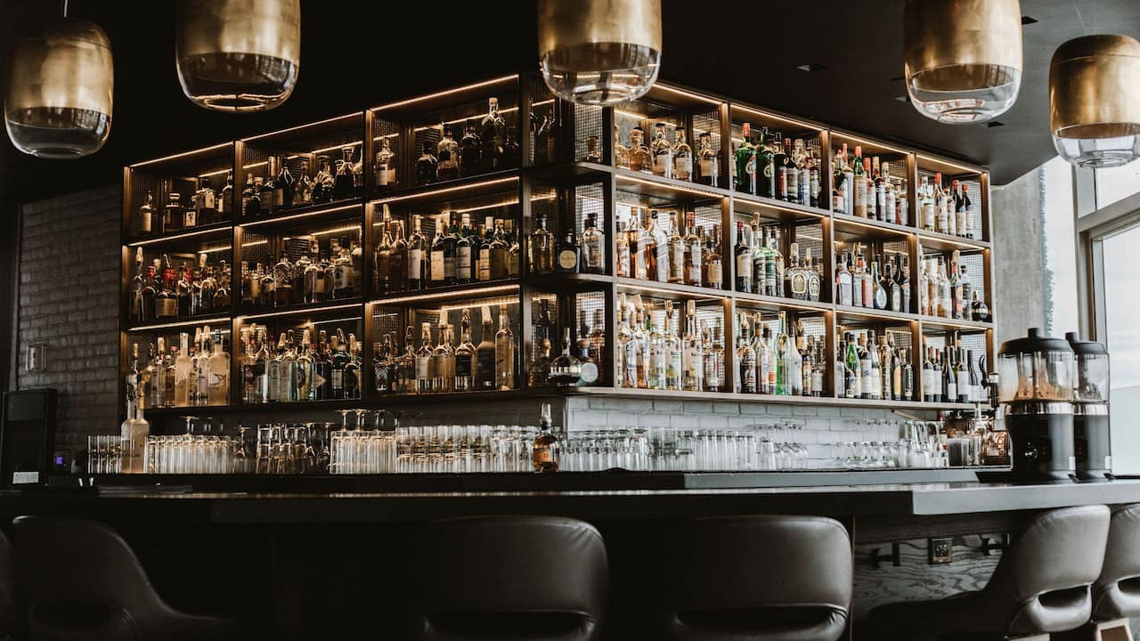 Crown Bar featuring a large liquor display, bar countertop, and bar stools