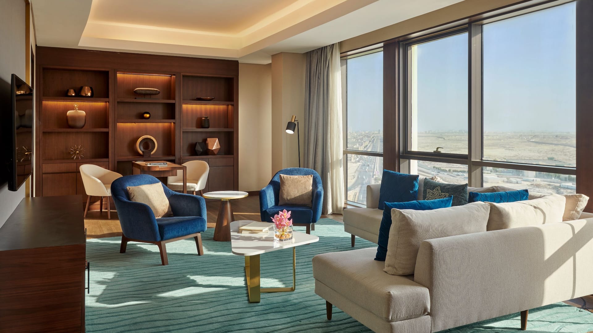 Spacious and elegantly designed living area in the Three Bedroom Apartment at Grand Hyatt Al Khobar, featuring modern furnishings, floor to ceiling windows, and a stunning city view