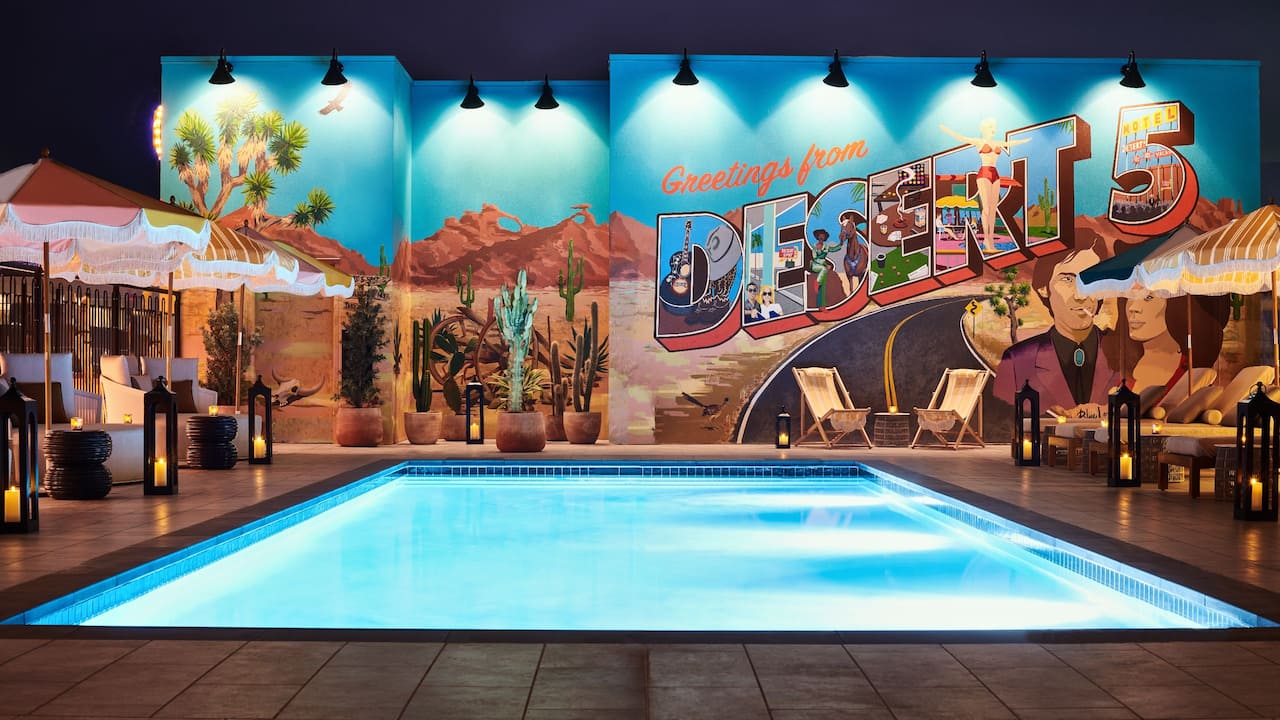 Rooftop pool with wall mural at night