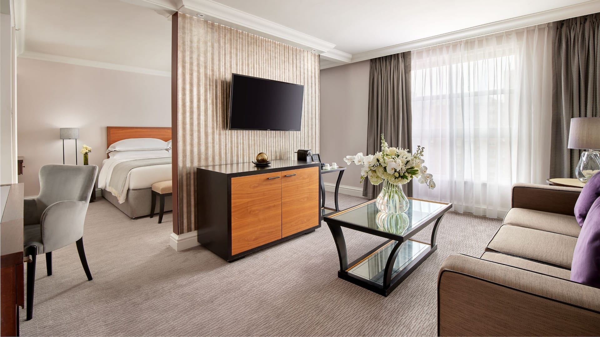 Regency Suite featuring bedroom and living room, highlighting classic furnishing and neutral tones in the living room.