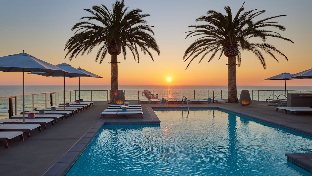 Rooftop pool with loungers at sunset