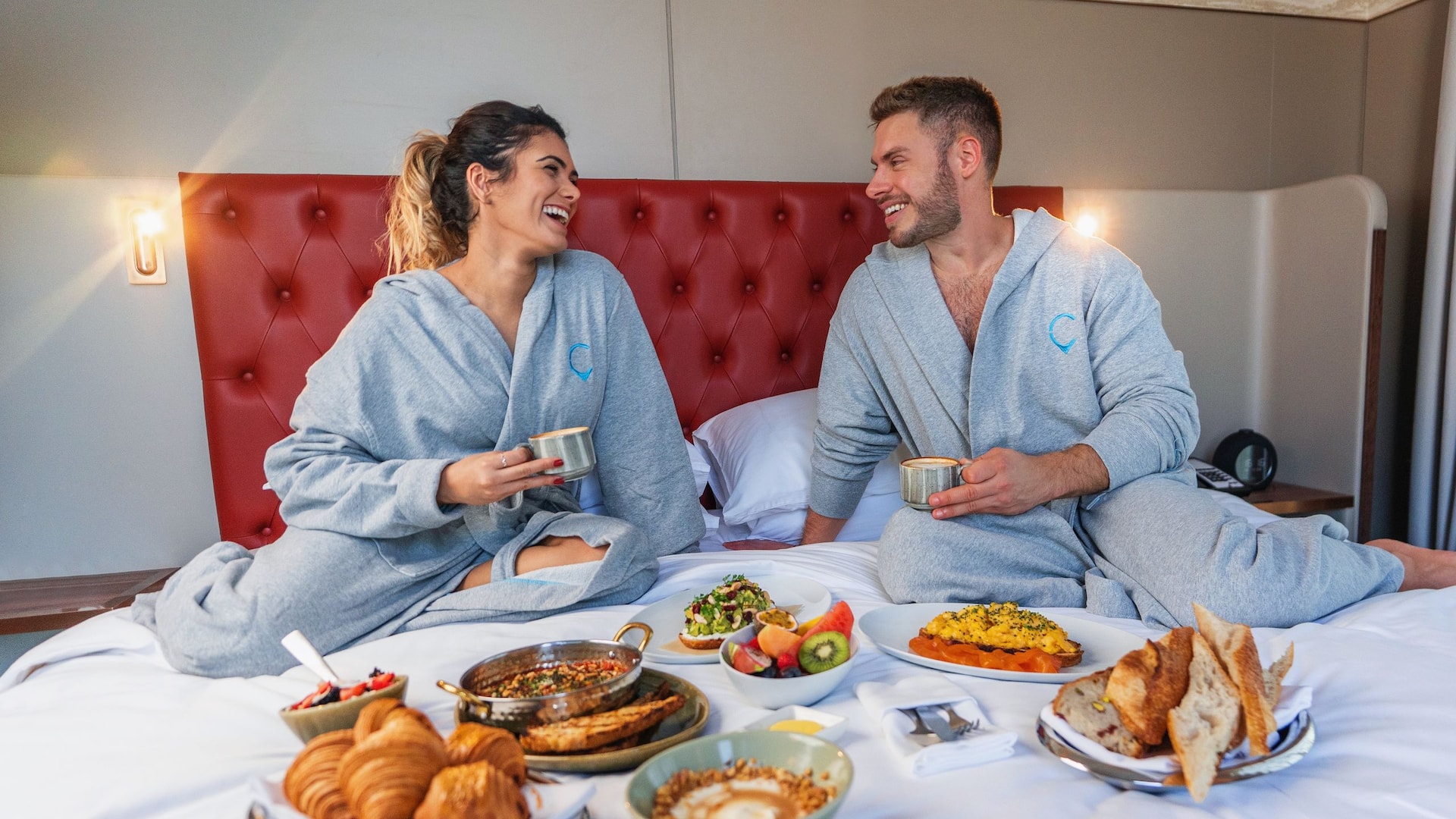 1 of 1 A couple enjoying a delightful hotel breakfast in bed in the comfortable room at Hyatt Centric Jumeirah Dubai