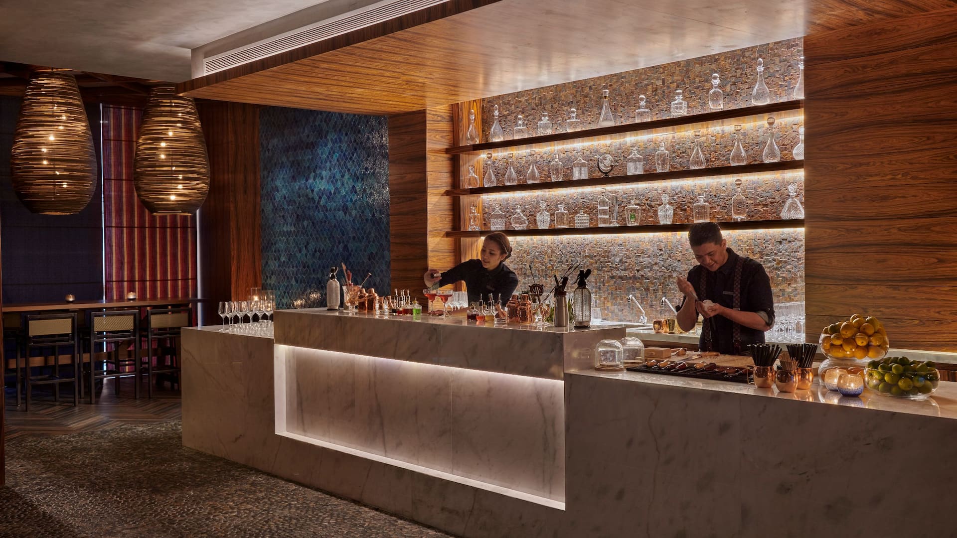1 of 1 Sakana House at Grand Hyatt Al Khobar a sophisticated multi Asian restaurant with a stylish marble bar, warm ambient lighting, and an elegant display of glassware, Bartenders craft signature drinks and dishes in an intimate setting