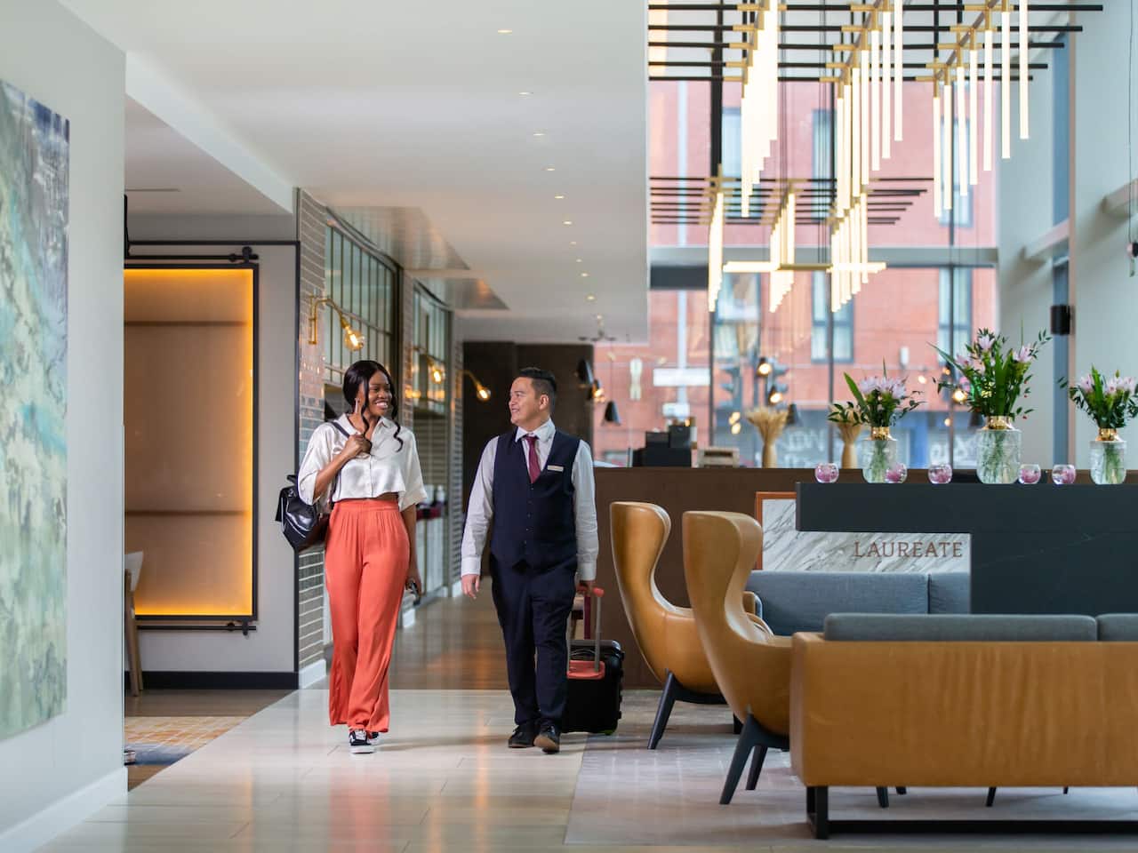 Guest walking through the lobby with a member of reception team 