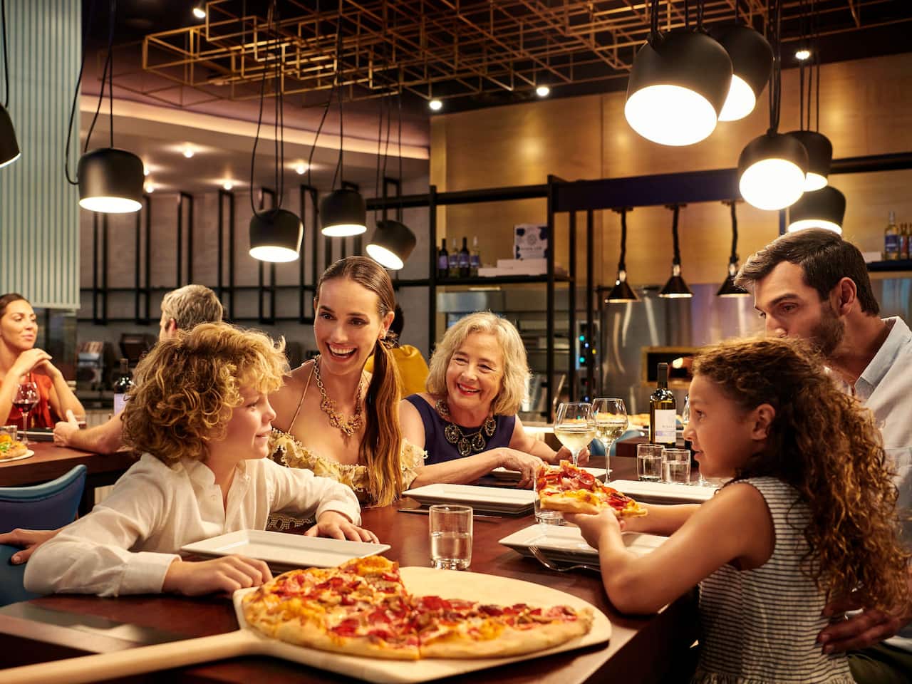 A family enjoying pizza at a restaurant in the Bahamas