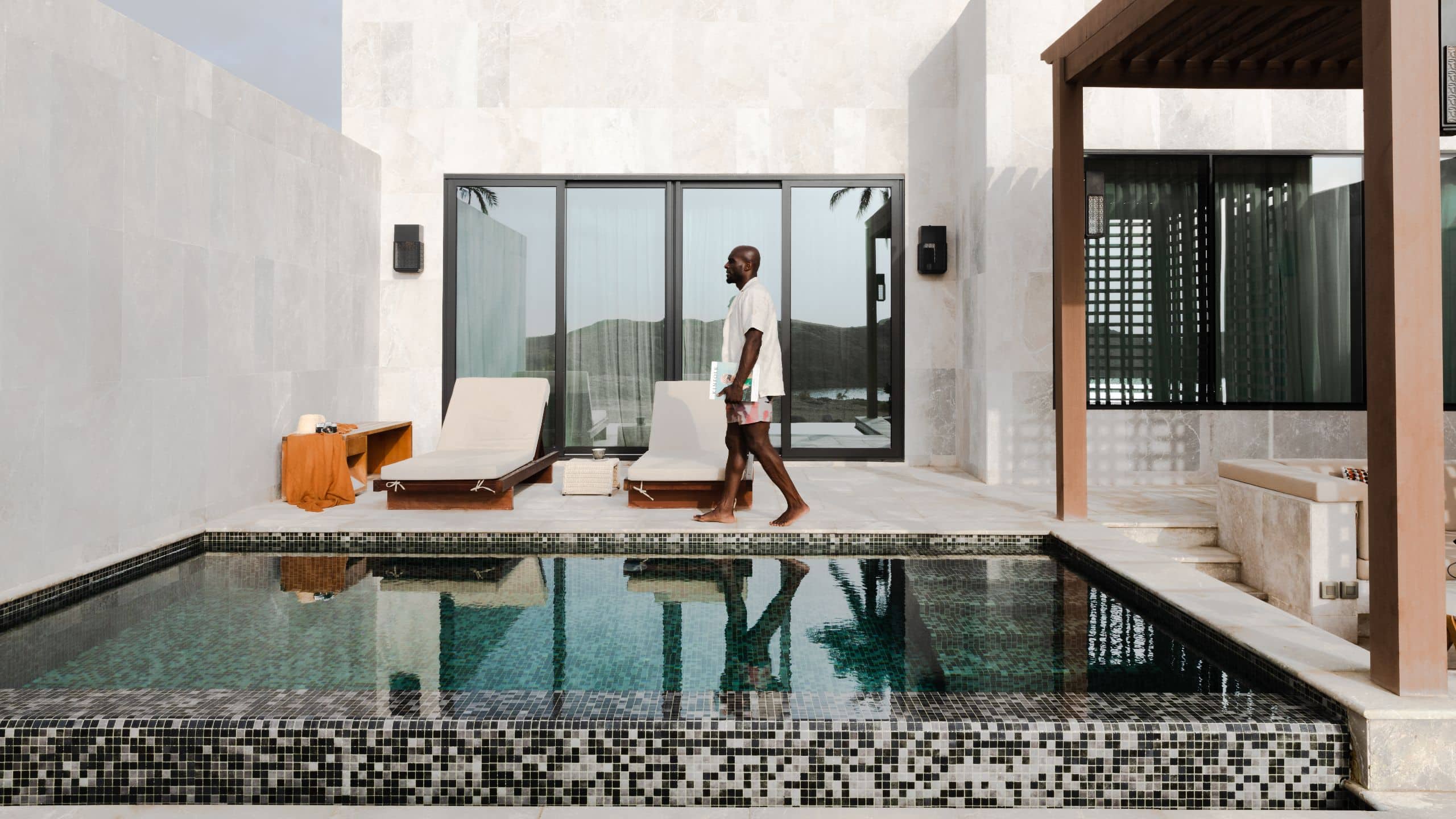 2 из 5 Alila Hinu Bay Man Walking Poolside