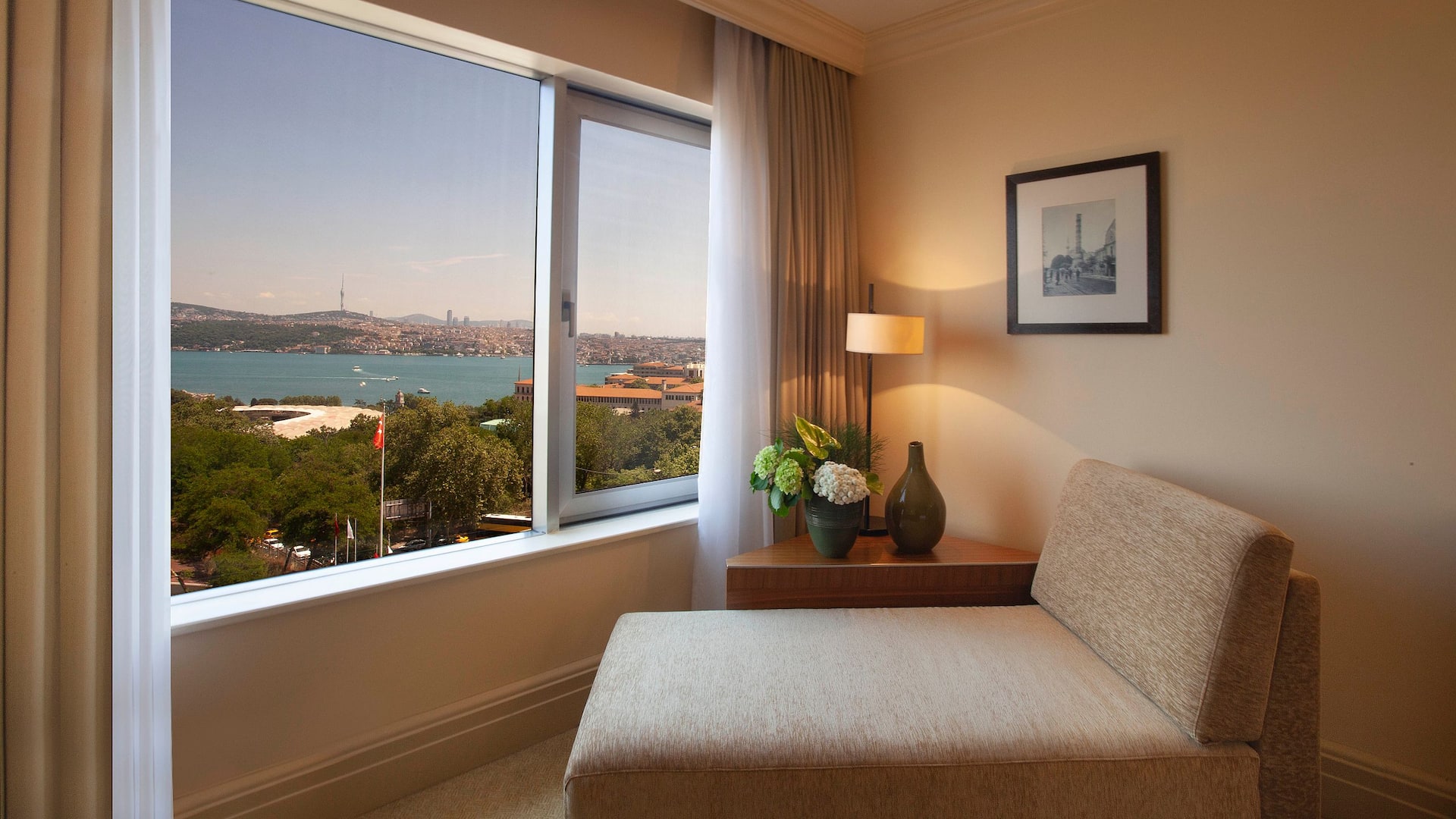 1 de 5 Grand Hyatt Istanbul's room with a stunning Bosphorus view, featuring a comfortable sofa, and fresh flowers in a natural-colored setting.