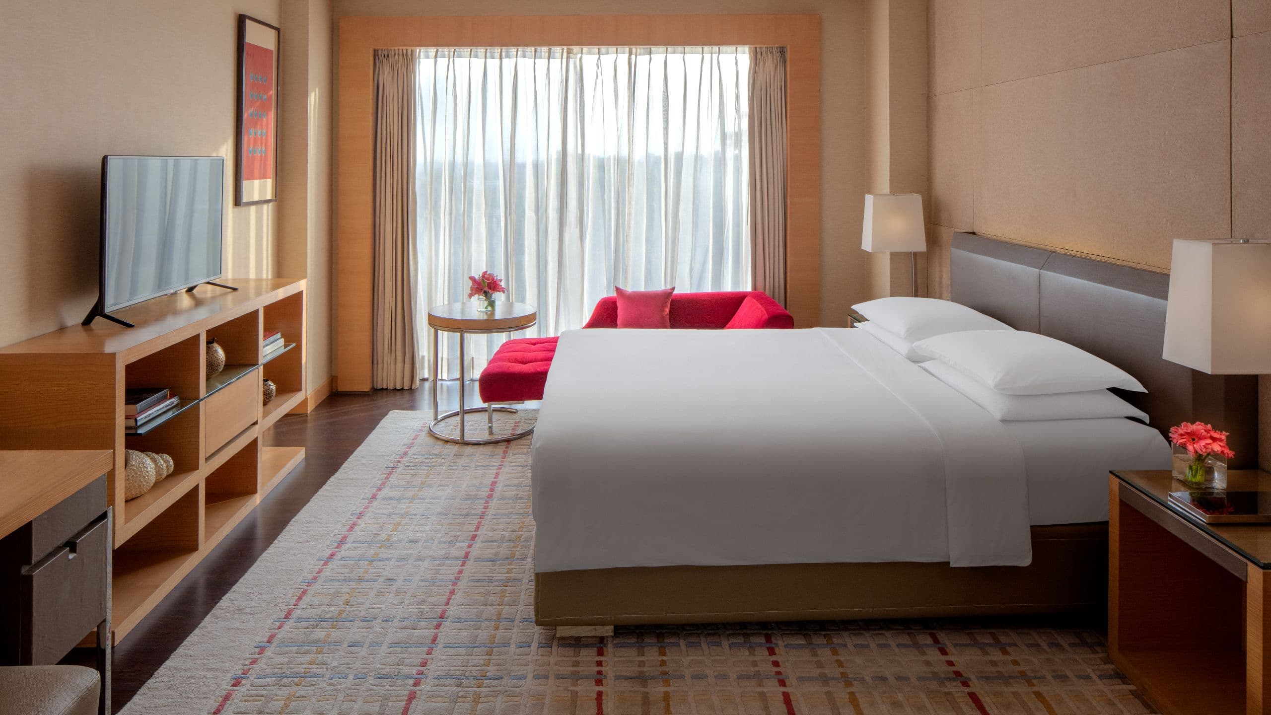 King sized bed by large window in hotel suite