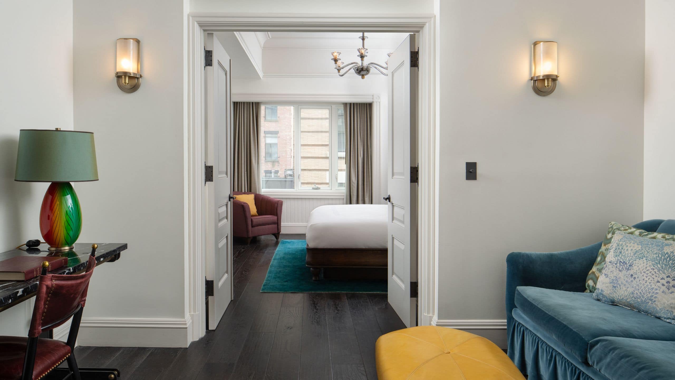 View from a suite seating area into the bedroom with a large window