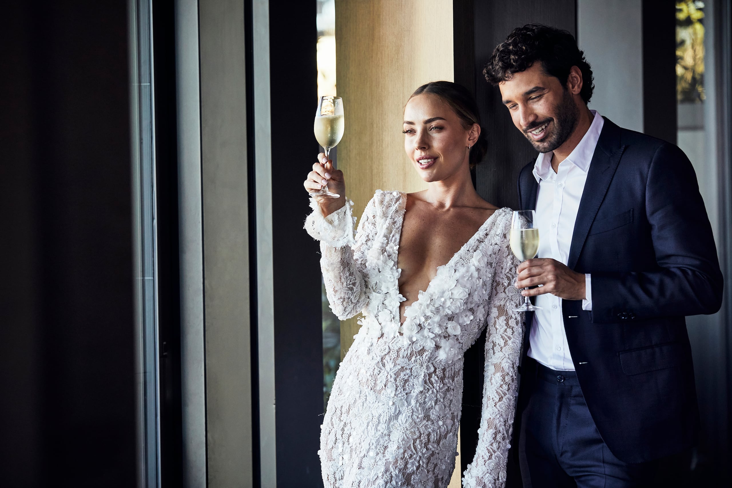 Wedding couple in love drinking champagne at the Hyatt Regency Dusseldorf and enjoying the view