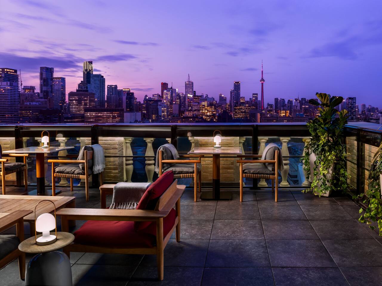 A elegant spacious rooftop bar with a view of the Torononto city skyline