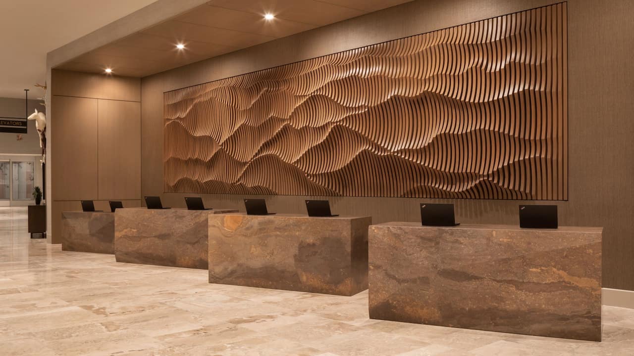 Modern front desk with a sleek marble surface and rustic wooden background