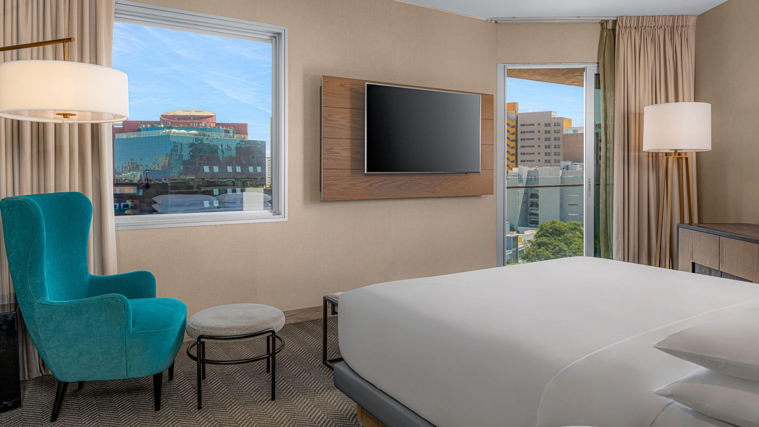 1/1 One King Bed Balcony guest room with reading chair, large windows and access to the balcony