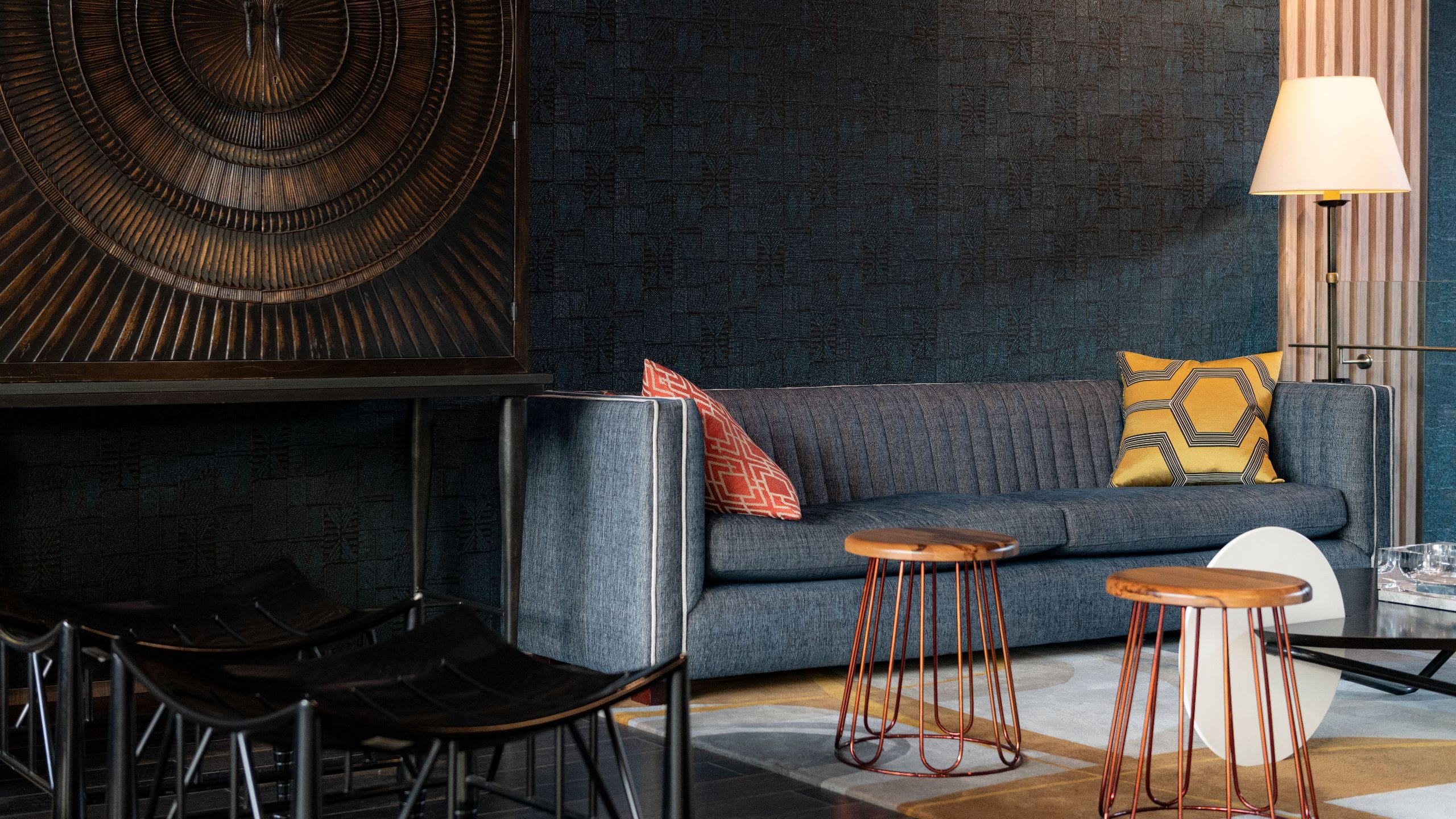 Lobby seating area with blue sofa and wooden stools