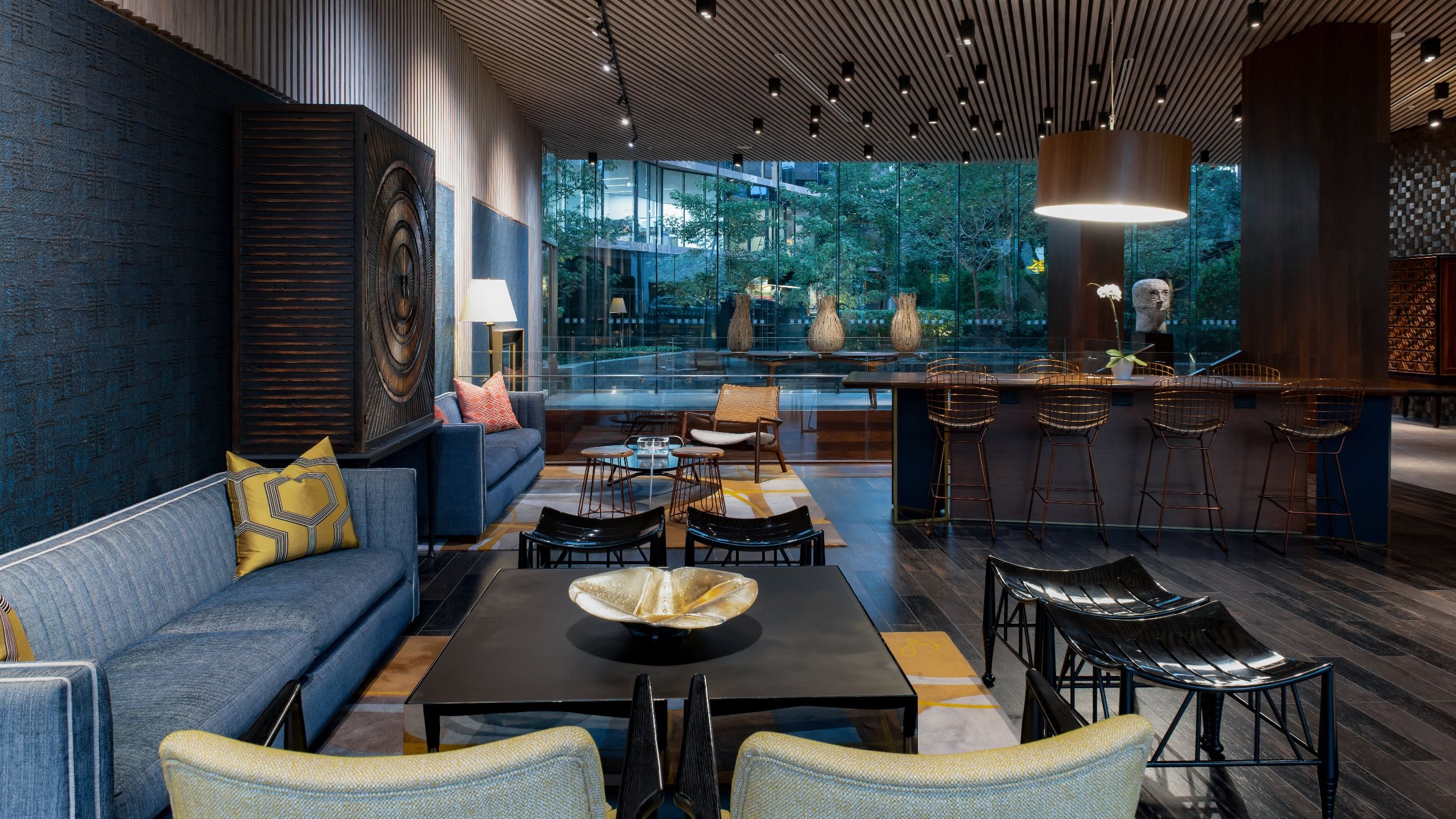 Lobby seating with two sofas, a communal table and views of outside