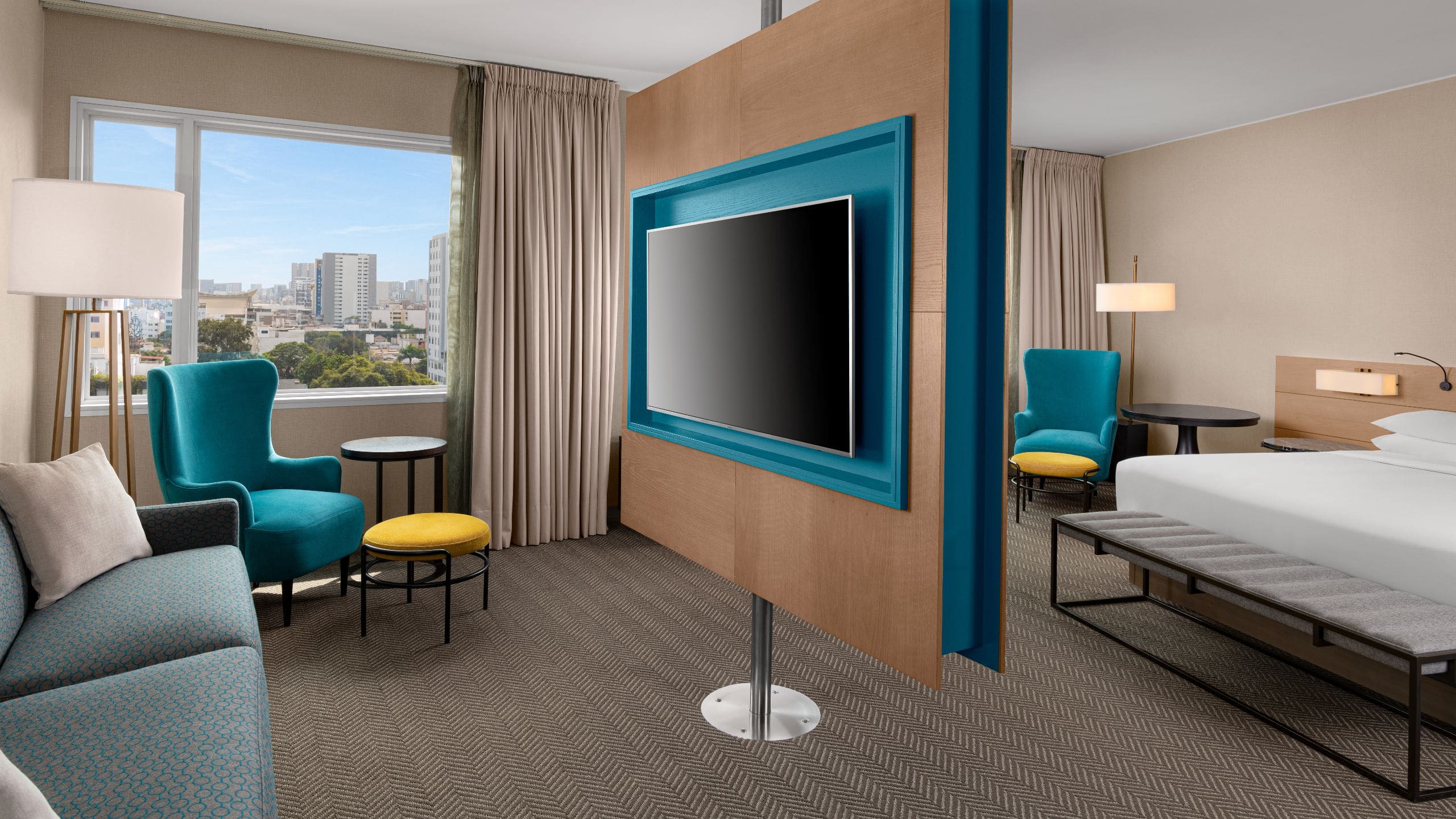 1/1 Junior Suite with King Bed sitting area with large television, sofa and chair
