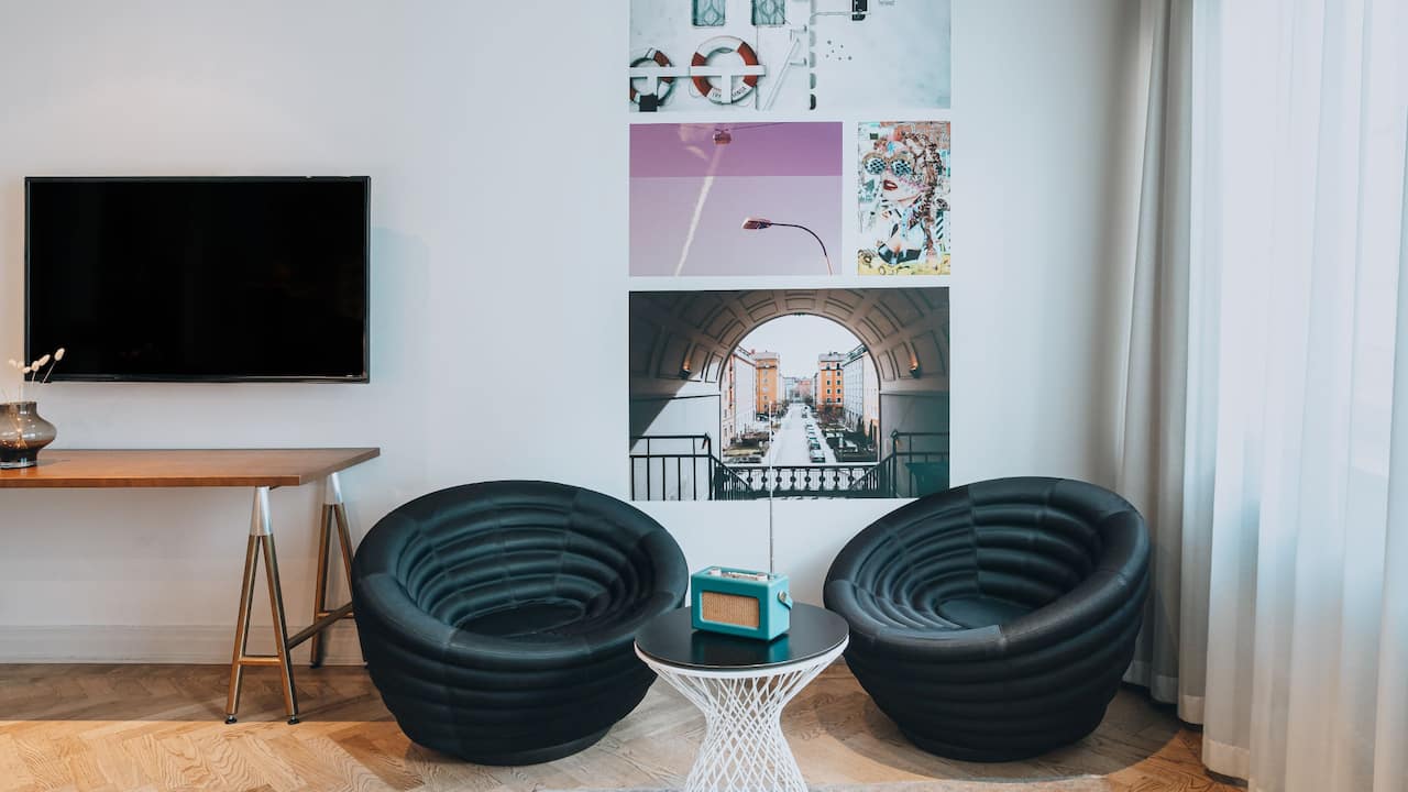 Seating area and wall art in the King bed deluxe room at Story Hotel Riddargatan 