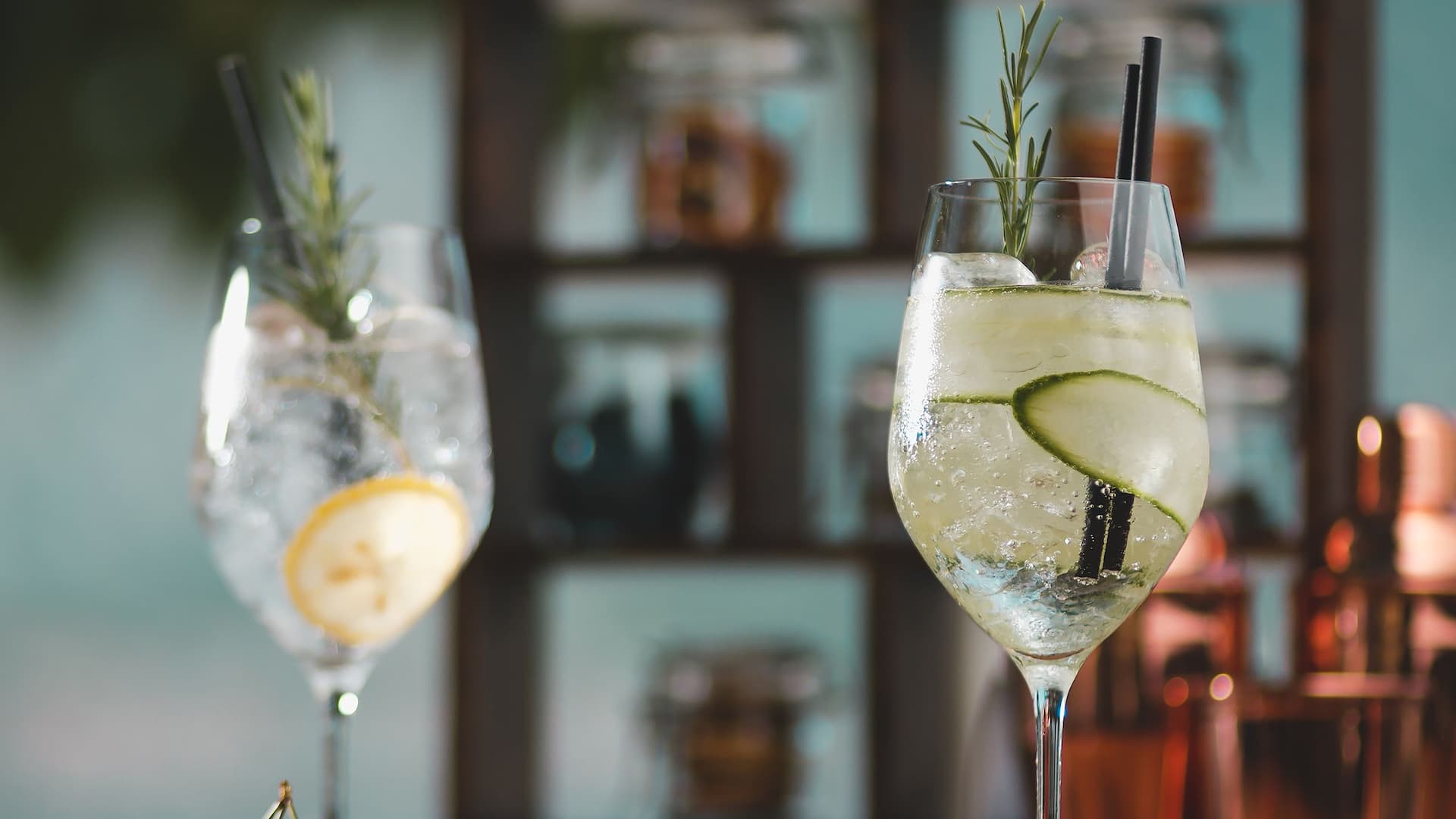 label.xOfY Two refreshing cocktails garnished with cucumber slices and sprigs of rosemary, served in elegant glasses at the Lobby Bar and Terrace.