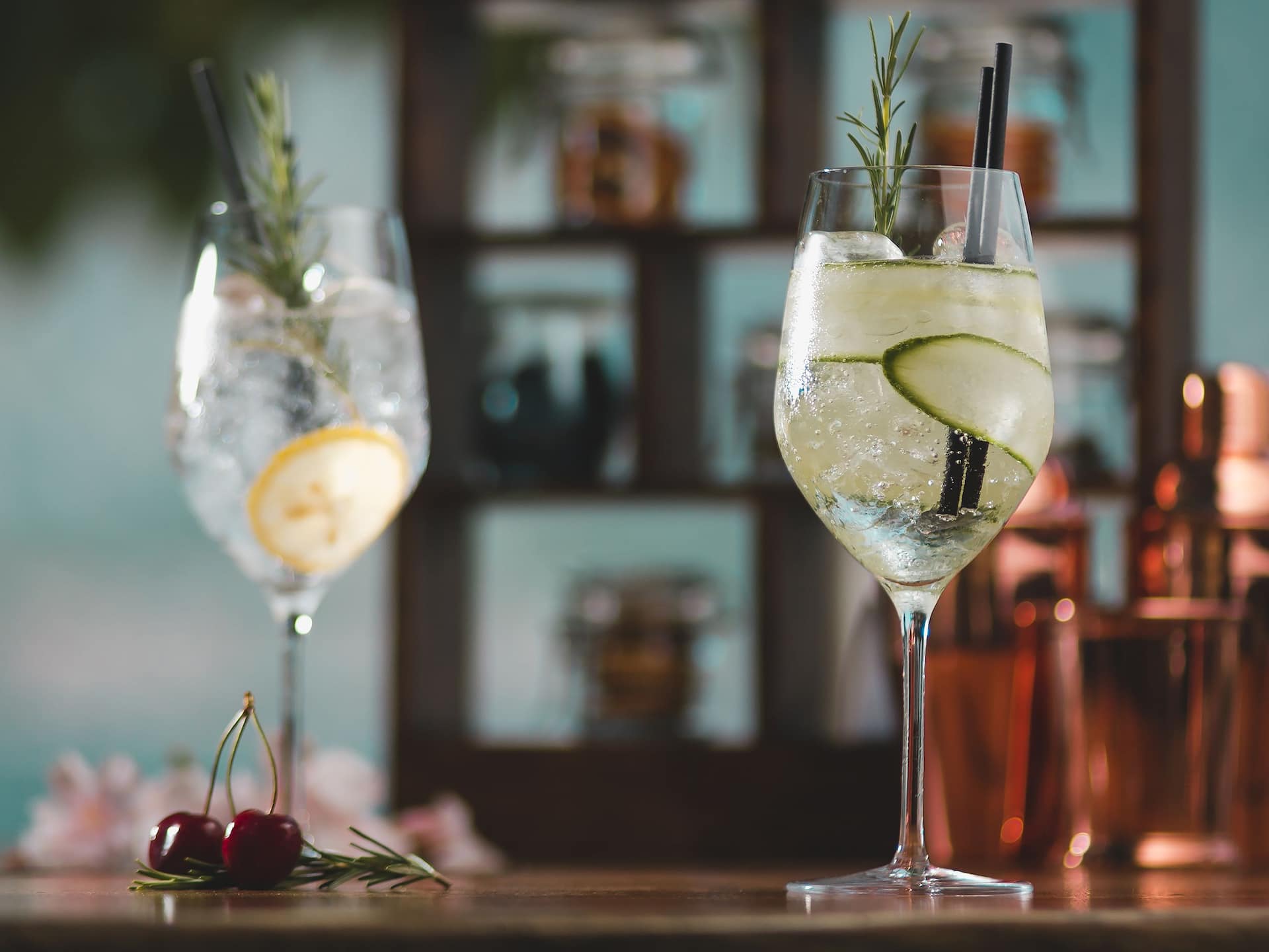 Two refreshing cocktails garnished with cucumber slices and sprigs of rosemary, served in elegant glasses at the Lobby Bar and Terrace.