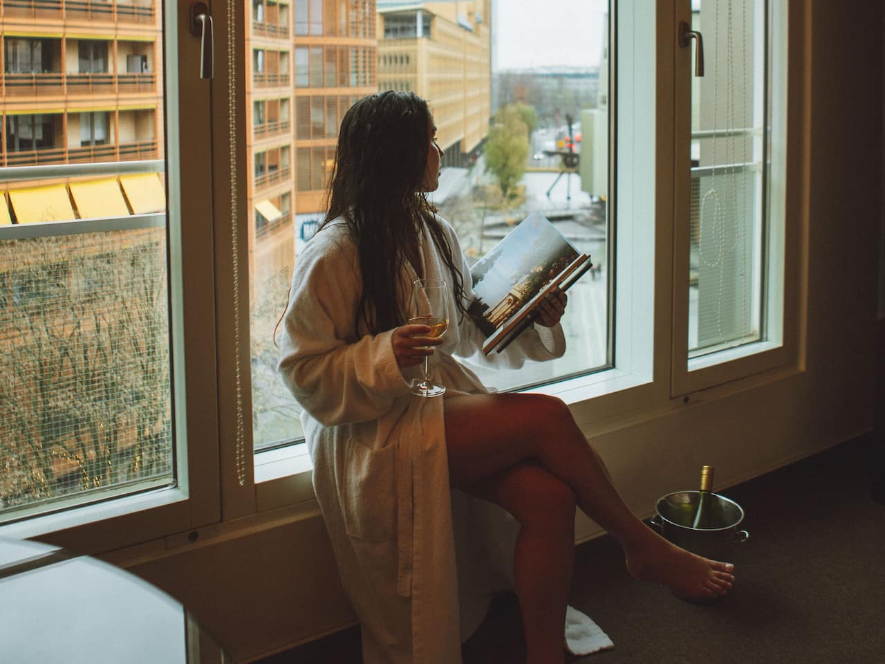 Grand Hyatt Berlin Frau an Fenster mit Champagner