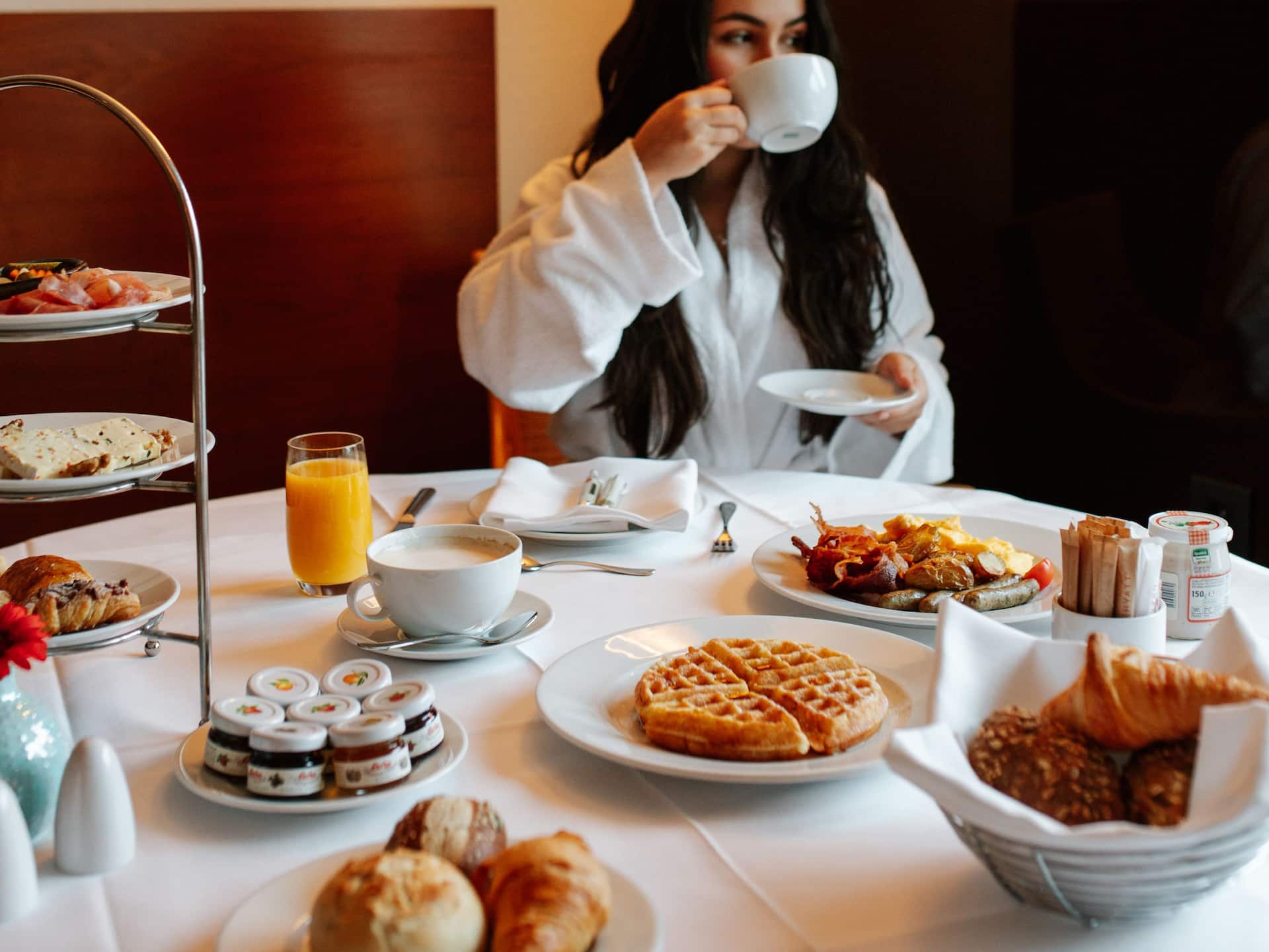 Room Service Frühstück in der Daimler Suite mit frisch gepresstem Saft, Waffeln und einer großzügigen Auswahl an Köstlichkeiten im Grand Hyatt Berlin.