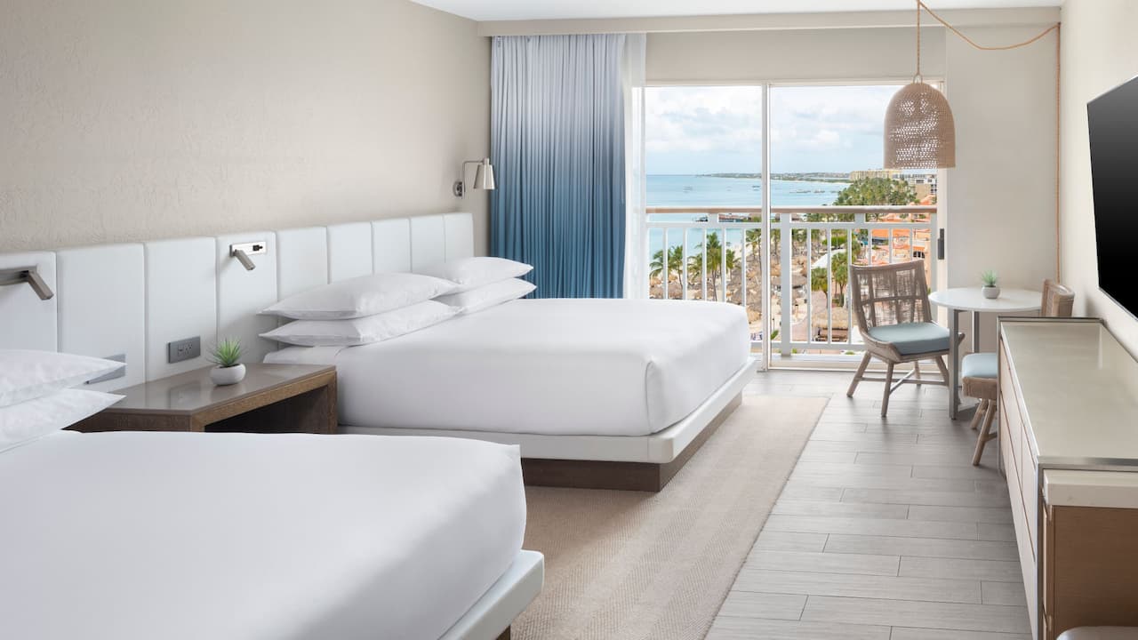 Two Queens Resort and Ocean View guestroom with table and tv