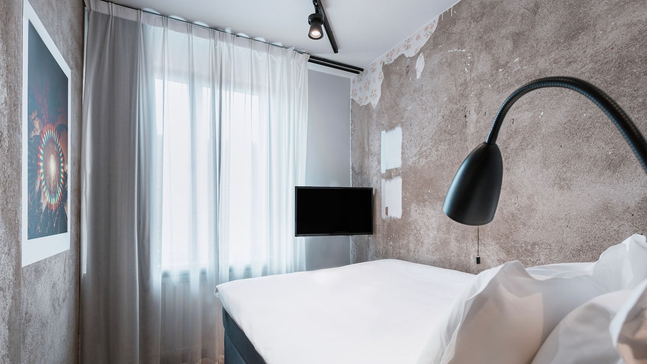 Story Hotel Riddargatan photo of whole double room with bed, wall art, TV and pillows and lamp