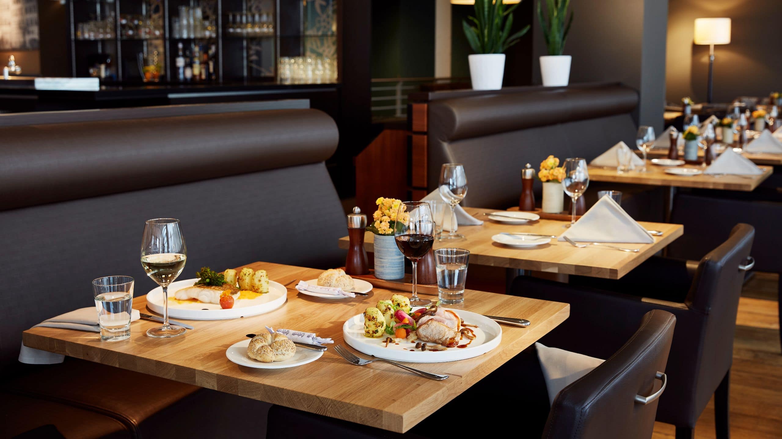 Elegantes Hotelrestaurant mit gedeckten Tischen, serviertem Essen und einladender Atmosphäre 