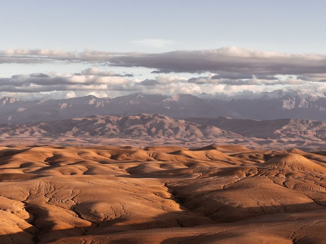 Sand dunes with distant mountains and Agafay Desert