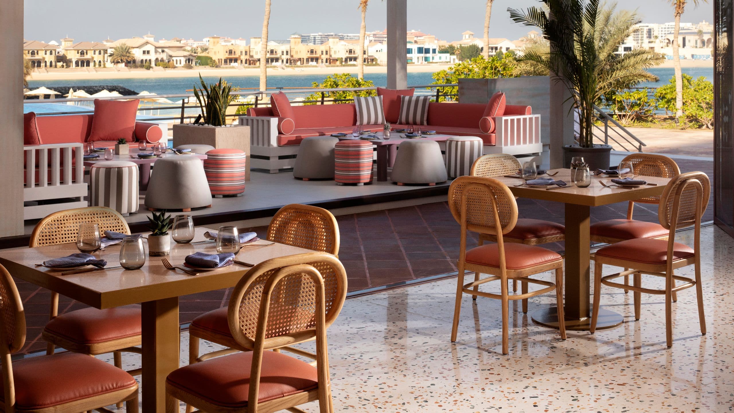 A stylish restaurant with semi-outdoor seating area and panoramic view of Jumeirah neighborhood.