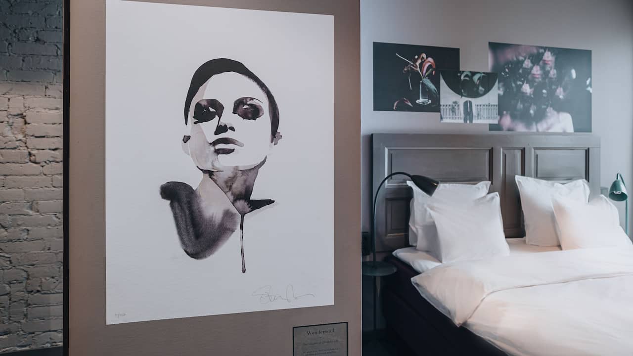 Black and white wall art to the left and headboard of the bed to the right in King Bed Room
