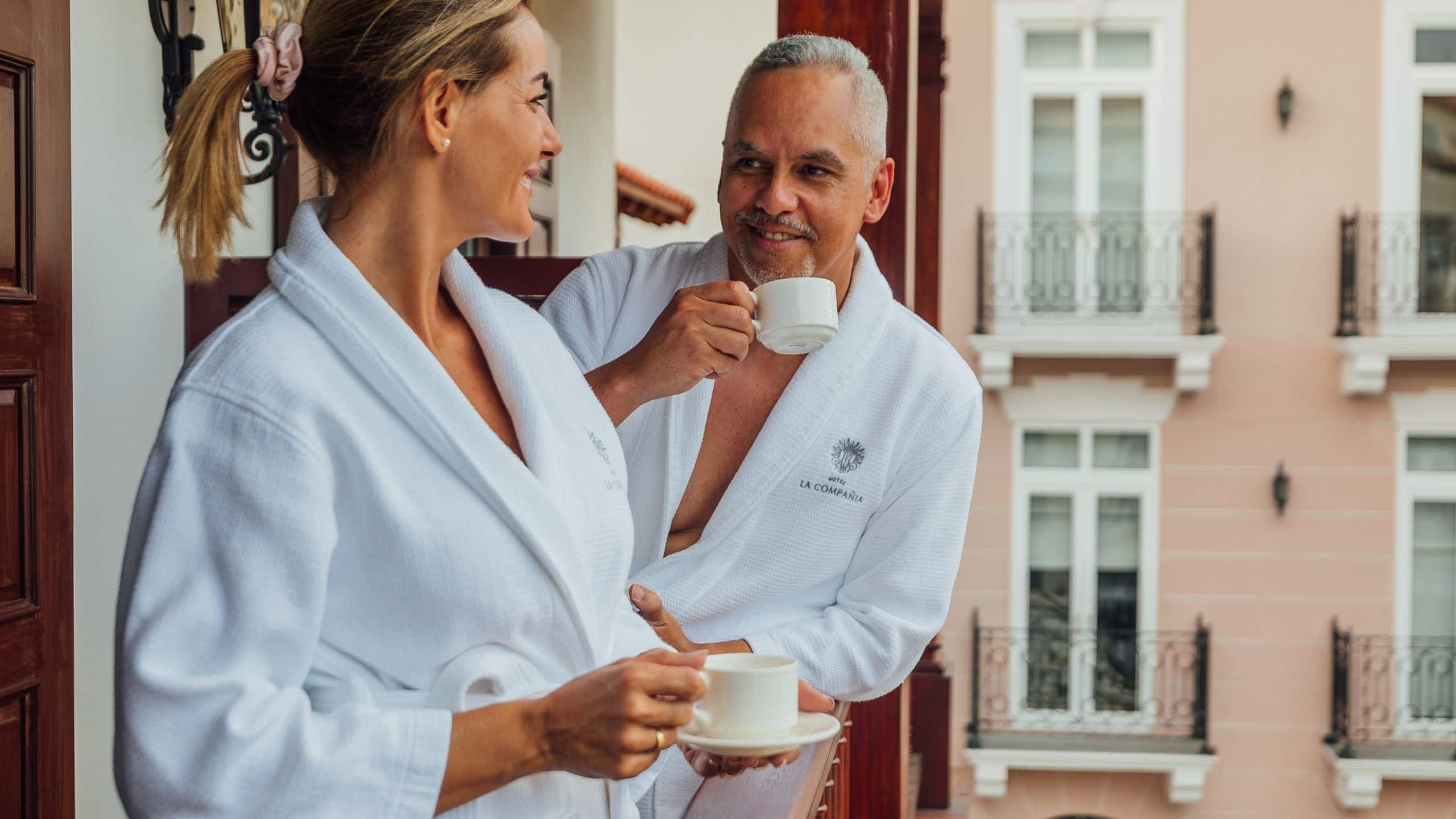 Hotel La Compañia Couple Balcony Drinking Coffee