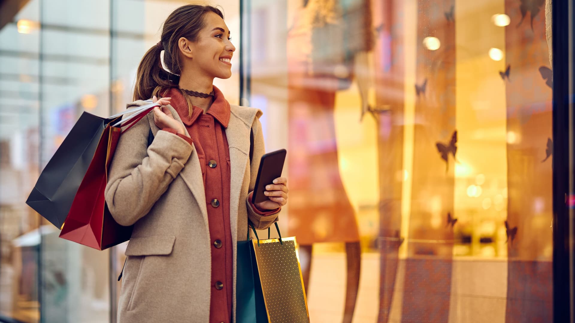 Woman goes shopping and stands in front of shop window
